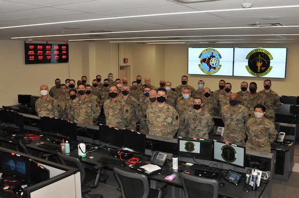 Members in Air Force battle uniform pose for a group photo wearing masks.