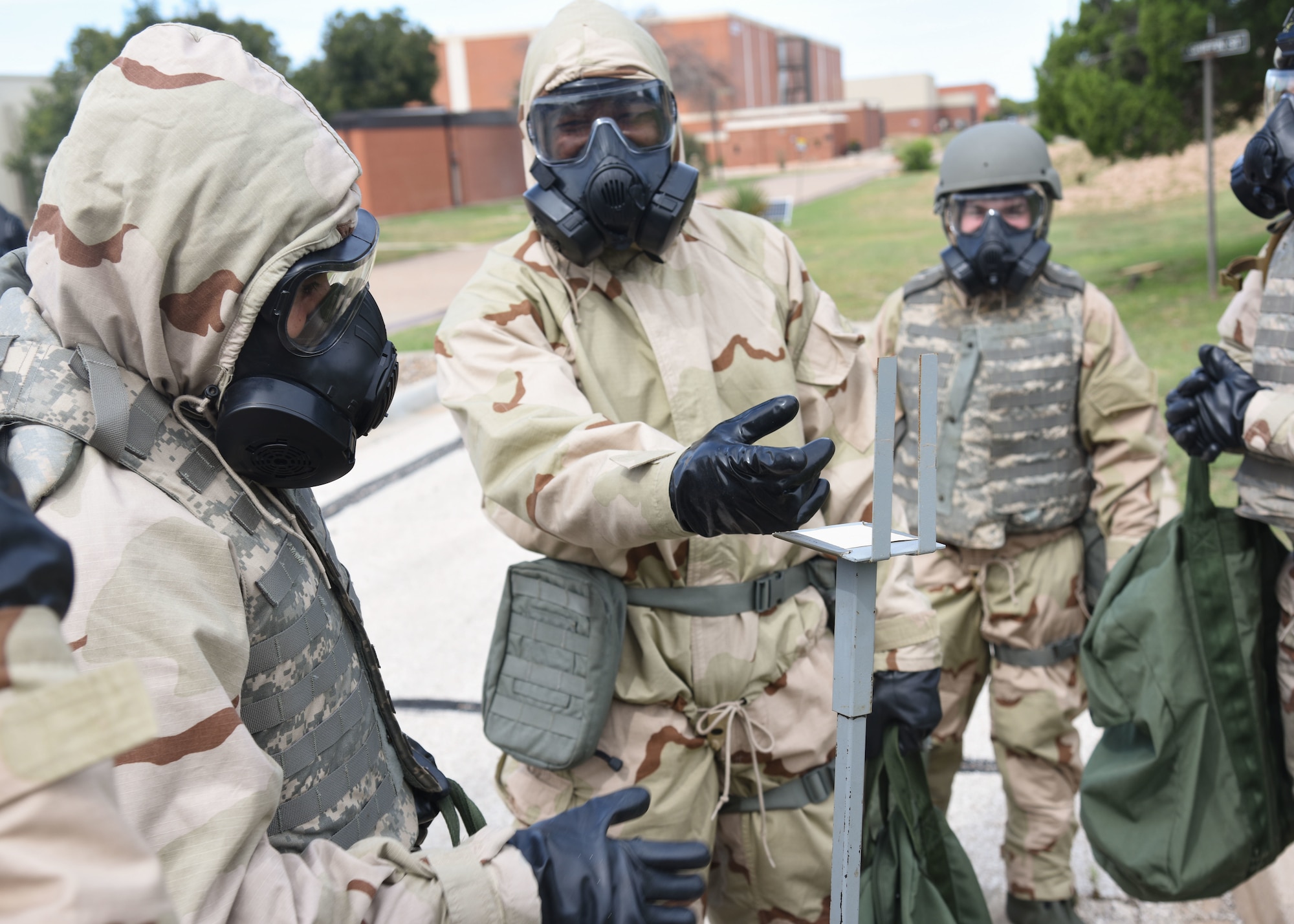 Goodfellow members discuss findings on simulated M8 paper during an Expeditionary Readiness Training on Goodfellow Air Force Base.