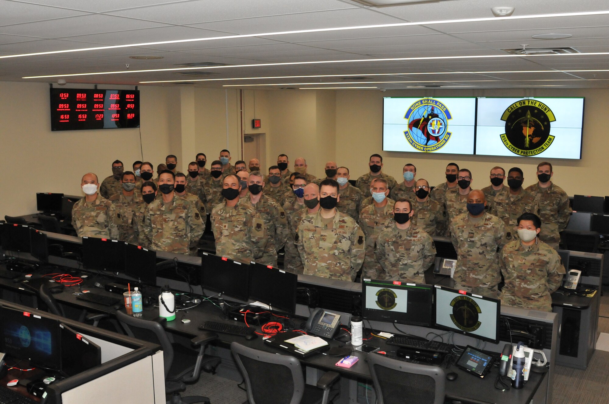 Members in Air Force battle uniform pose for a group photo wearing masks.