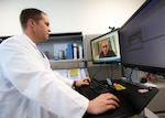 doctor in white coat looking at computer screen