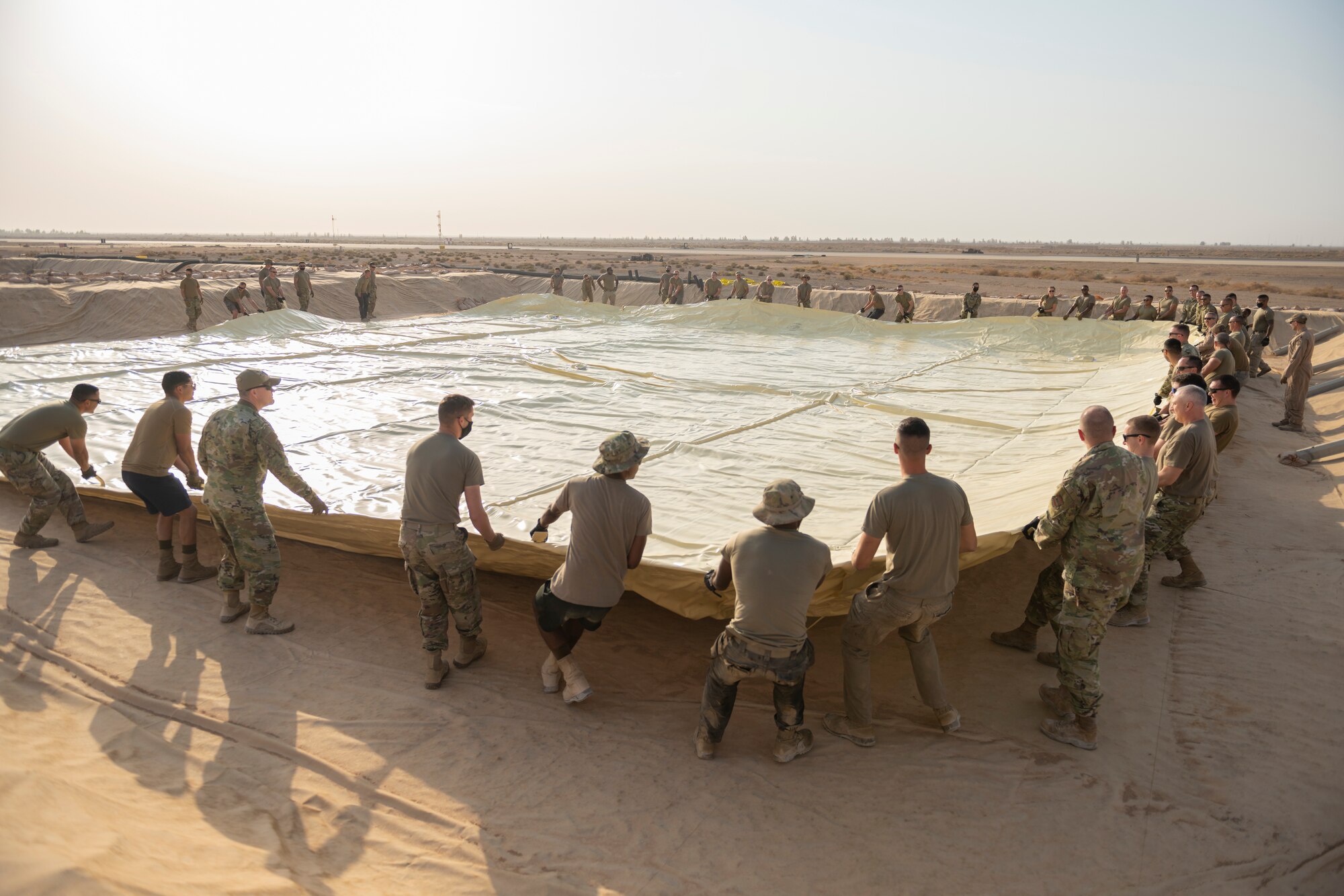 U.S. Airmen with the 332nd Air Expeditionary Wing spread out a collapsible fabric tank