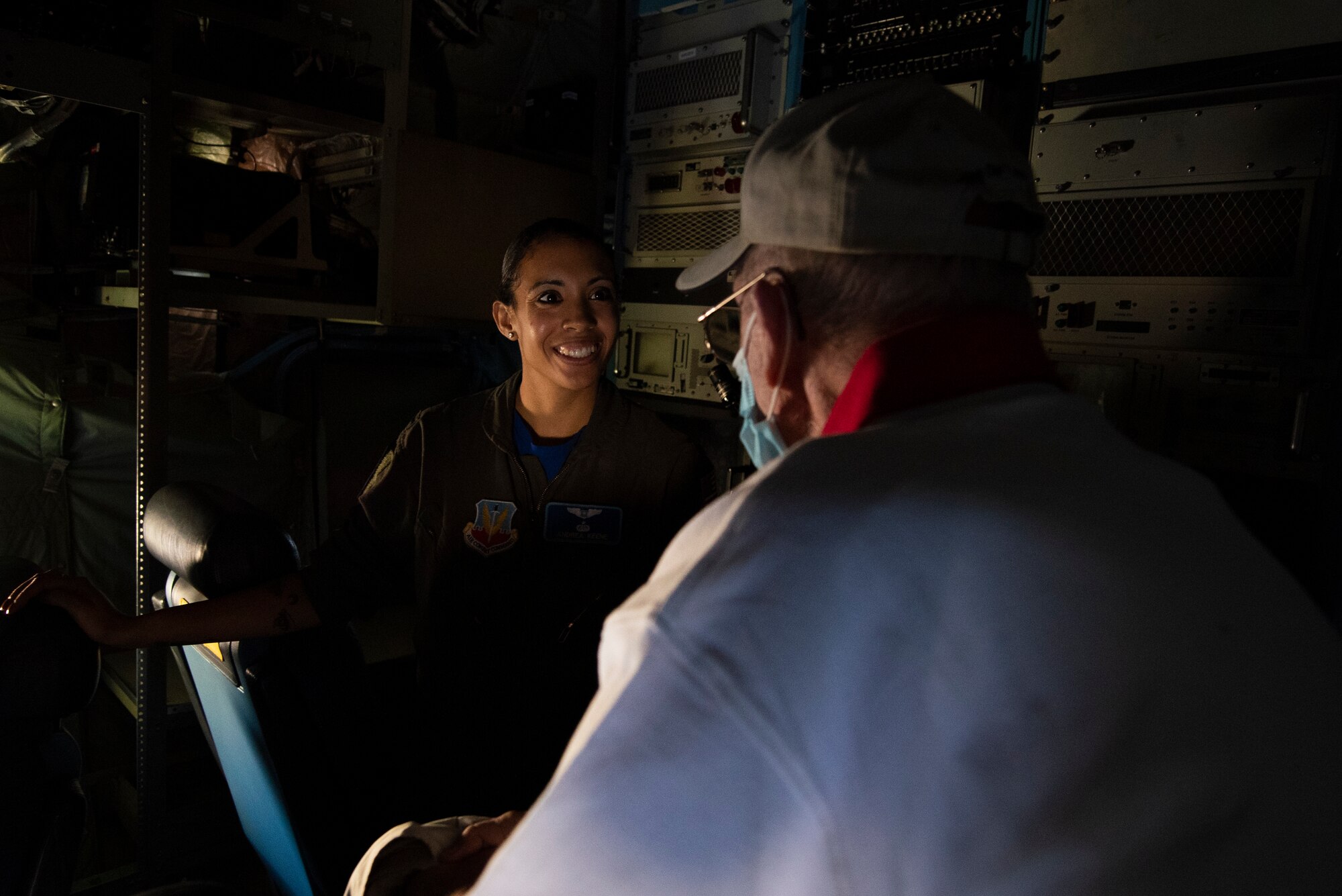 An active duty member talks to a retiree inside an aircraft