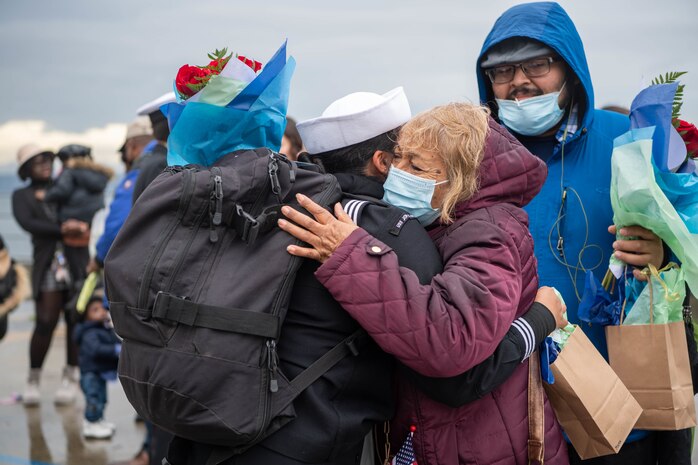 A Sailor, assigned to the Arleigh Burke-class guided-missile destroyer USS John S. McCain (DDG 56), greets her family after arriving at Naval Station Everett, Washington, October 16, 2021.