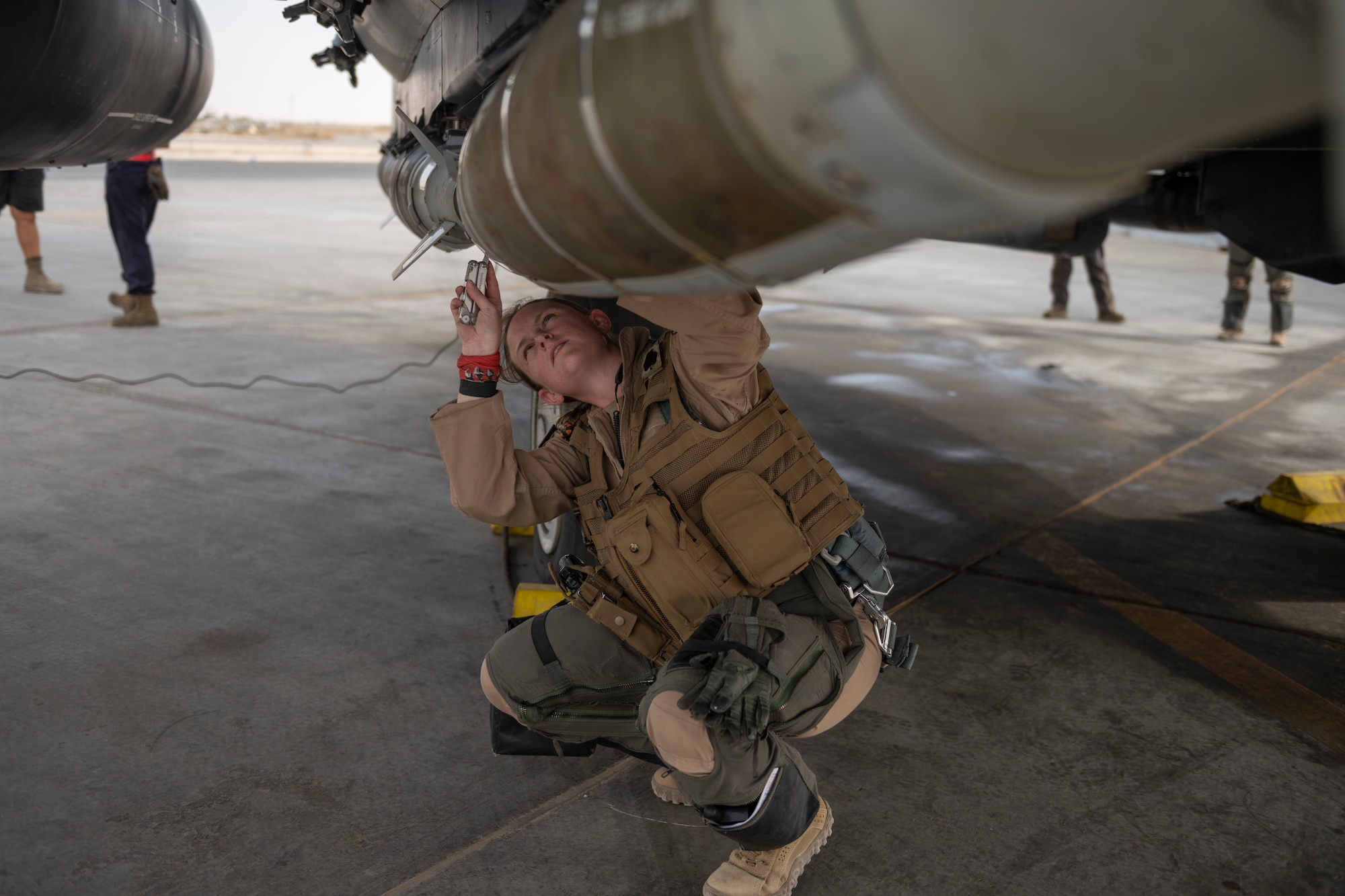 An F-15E Strike Eagle weapons system officer does a preflight check on her aircraft