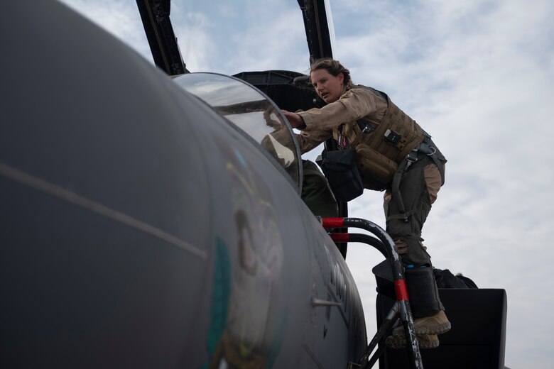 An F-15E Strike Eagle pilot climbs into her jet