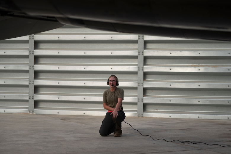 An Airman kneels next to an F-15E Strike Eagle
