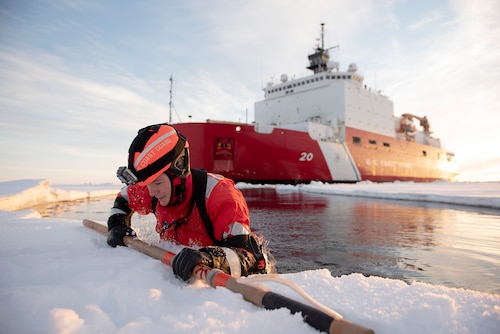 US Coast Guard Petty Officer 3rd Class Shannon Eubanks pulls herself out from the Arctic Ocean during ice rescue training