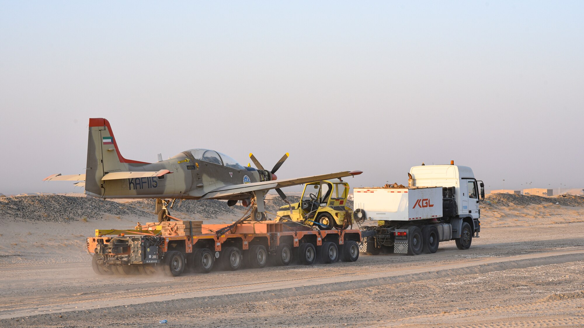 Multi-national forces transport a Kuwait Air Force Tucano aircraft from Al Mubarak Air Base, Kuwait, to Ali Al Salem Air Base, Kuwait, Oct. 15, 2021.