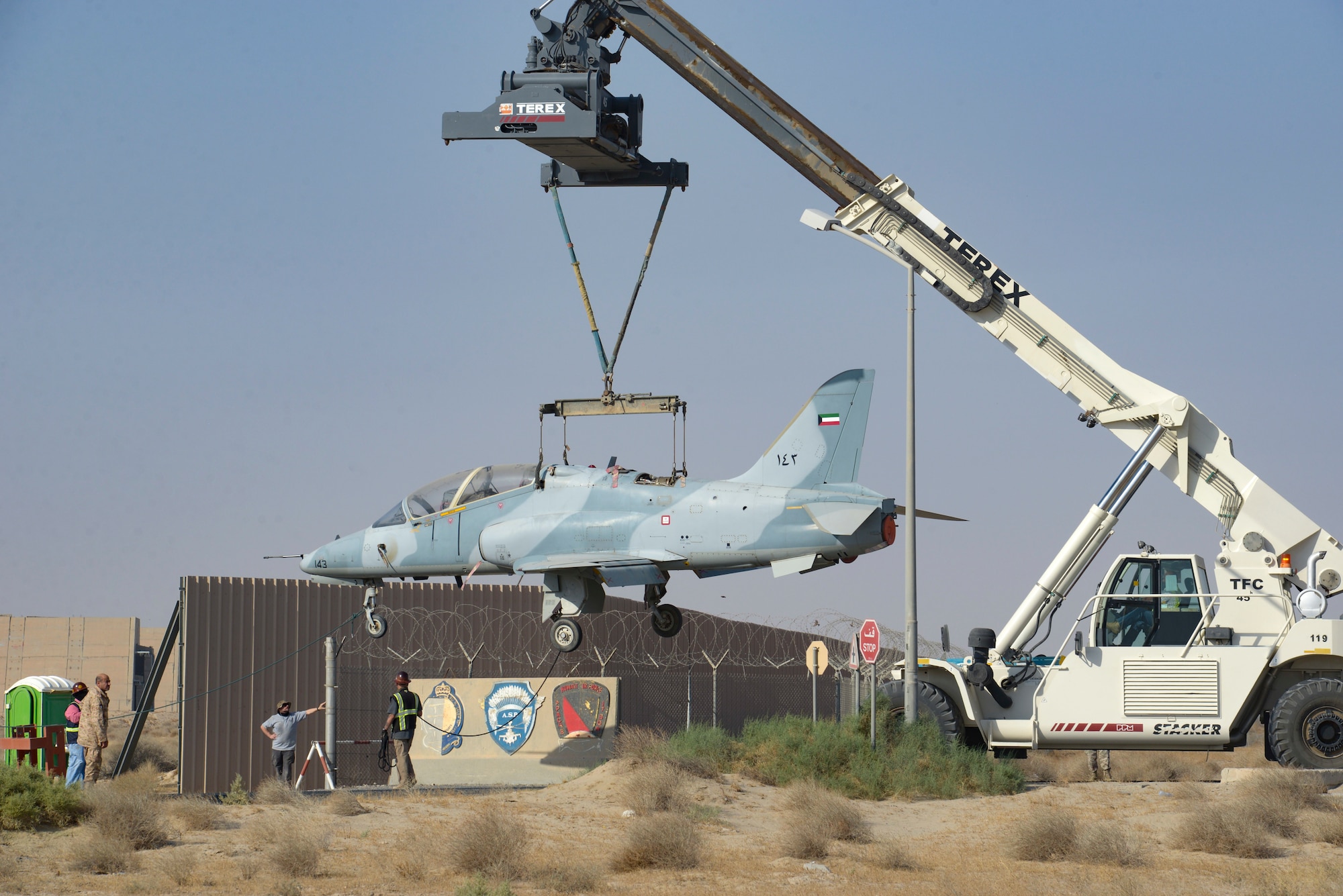 Multi-national forces lift a Kuwait Air Force Hawk aircraft over a gate on Ali Al Salem Air Base, Kuwait from Oct. 15, 2021.