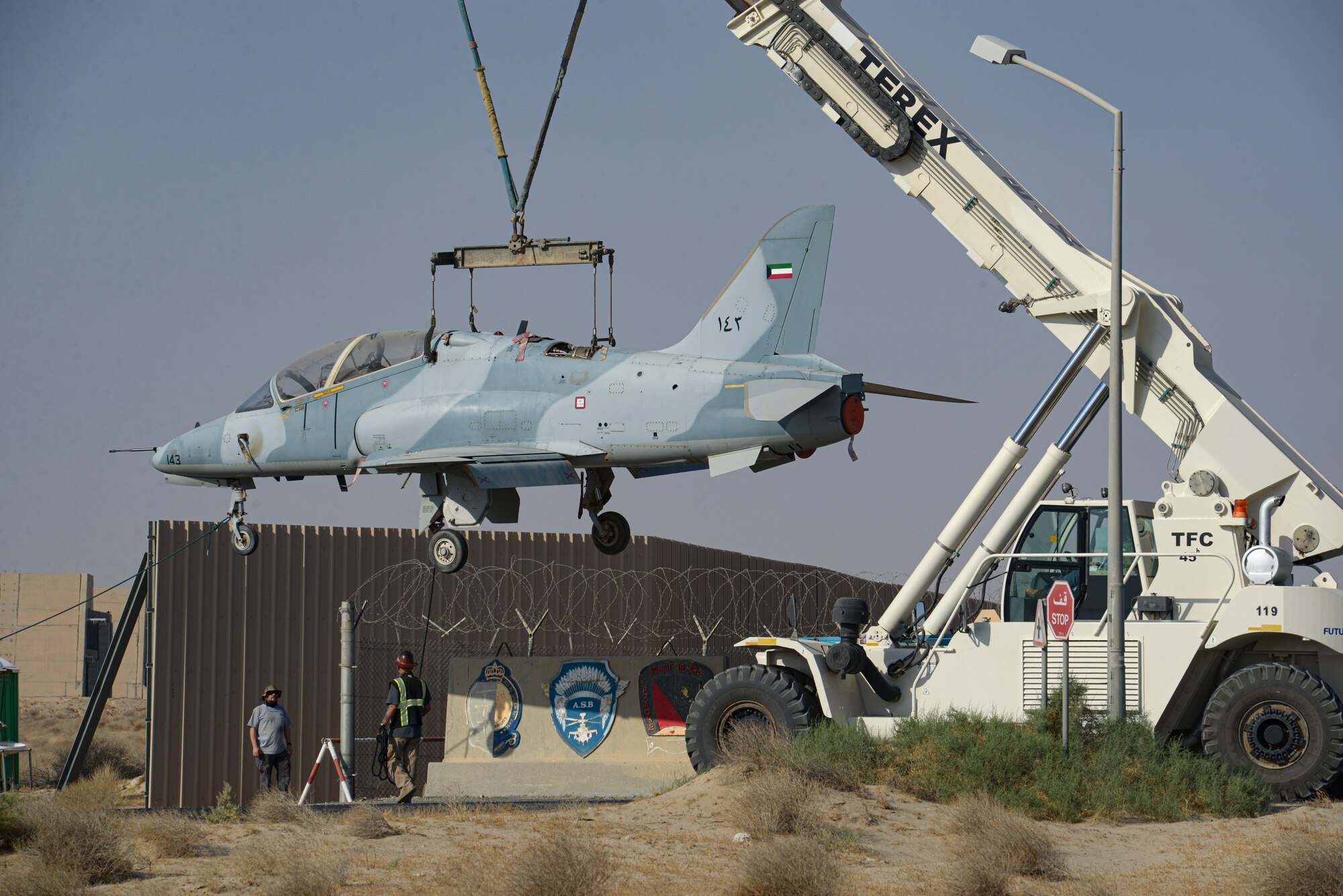 Multi-national forces lift a Kuwait Air Force Hawk aircraft over a gate on Ali Al Salem Air Base, Kuwait from Oct. 15, 2021.