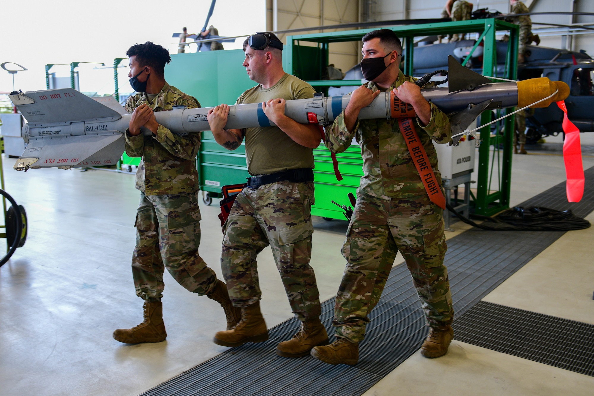 U.S. Air Force weapons load crew members assigned to the 555th Aircraft Maintenance Unit carry an AIM-9L/M Sidewinder to an F-16 Fighting Falcon during the 3rd quarter Rapid Aircraft Generation and Employment (RAGE) event at Aviano Air Base, Italy, Oct.7, 2021. The weapons load crews competed head-to-head and were tasked to load an F-16 Fighting Falcon with an inert guided bomb unit-31v3 Joint Direct Attack Munition (JDAM), a MK-84 Low Drag and one AIM-9L/M Sidewinder in the shortest amount of time. (U.S. Air Force photo by Senior Airman Brooke Moeder)