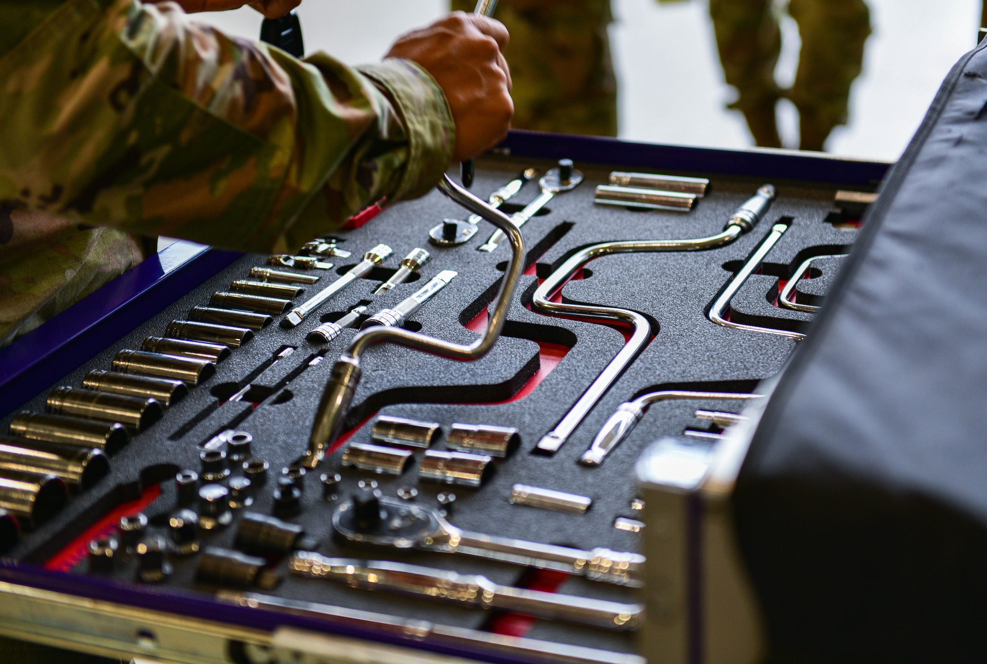 A U.S. Air Force Airman assigned to the 31st Maintenance Squadron picks up a tool during the 3rd quarter Rapid Aircraft Generation and Employment (RAGE) event at Aviano Air Base, Italy, Oct 7, 2021. RAGE held two competitions in which each team was evaluated on technical proficiency, safety procedures and overall time. (U.S. Air Force photo by Senior Airman Brooke Moeder)