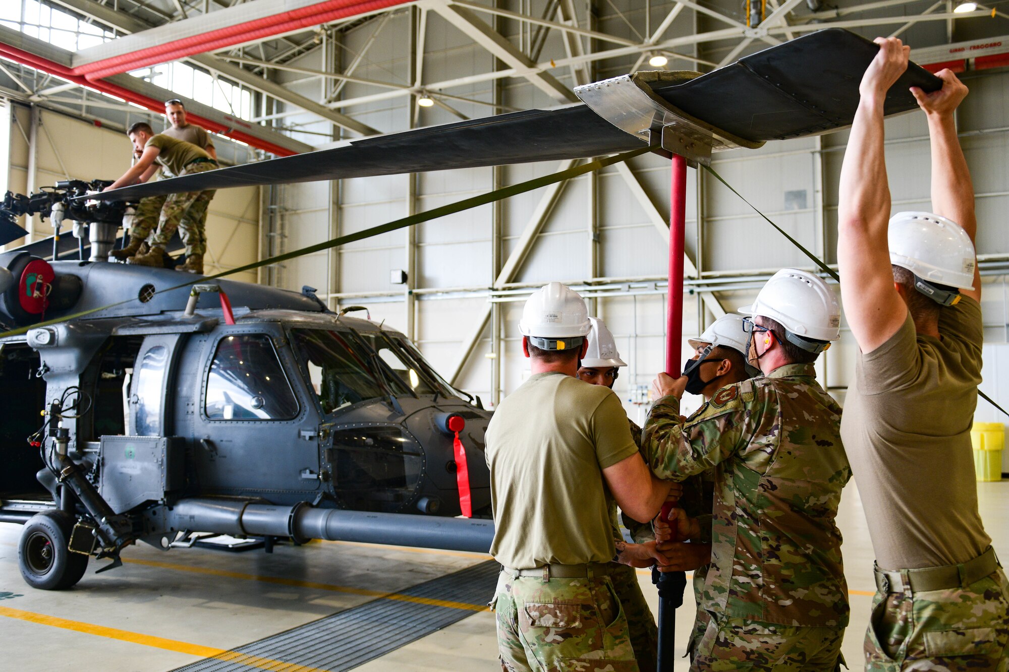 U.S. Air Force Airmen assigned to the 56th Helicopter Maintenance Unit compete in the 3rd quarter Rapid Aircraft Generation and Employment (RAGE) event at Aviano Air Base, Italy, Oct. 7, 2021. During RAGE, the team completed an unfold of an HH-60G Pave Hawk helicopter while simultaneously installing one GAU-18 .50 caliber machine gun and one GAU-1 minigun in a coordinated effort. (U.S. Air Force photo by Senior Airman Brooke Moeder)