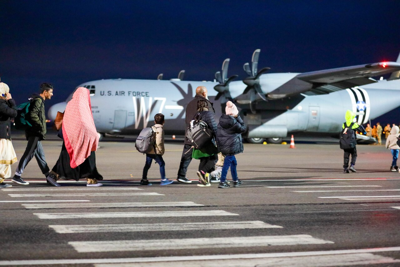 Afghanistan evacuees walk towards Air Force planes departing Kosovo.