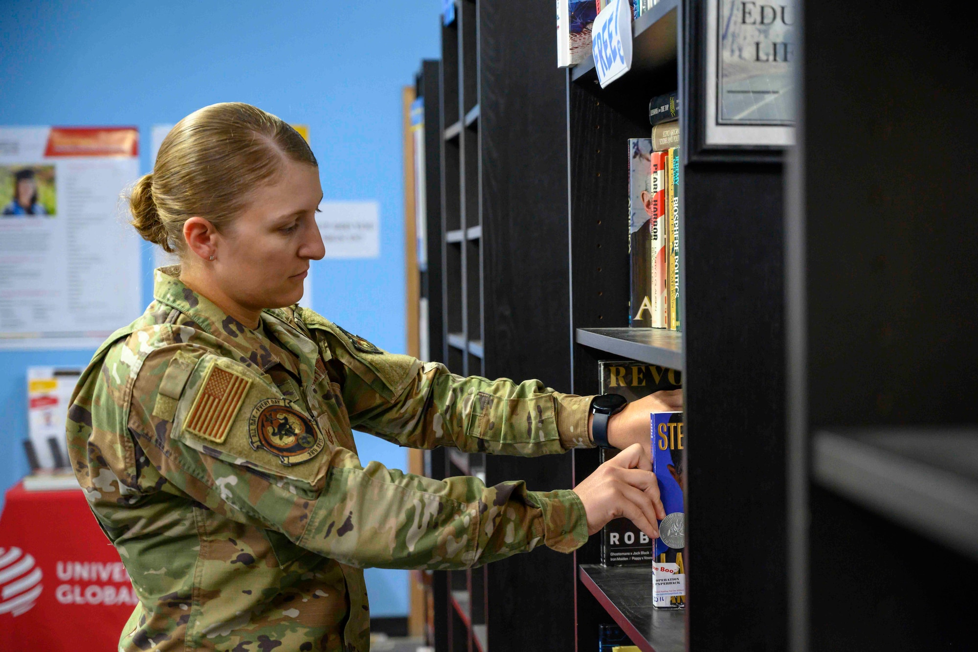 Airman stocking books on shelf