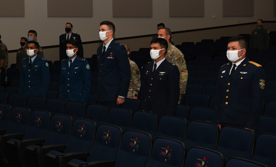 U.S Air Force and foreign allied forces Specialized Undergraduate Pilot Training graduates, stand at attention during the playing of the allied forces and United States National Anthems, Oct.22, 2021, on Columbus Air Force Base, Miss. One facet of training at Columbus AFB is the international training program where officers from allied forces are trained to be world class pilots. (U.S Air Force photo by Airman 1st Class Jessica Haynie)