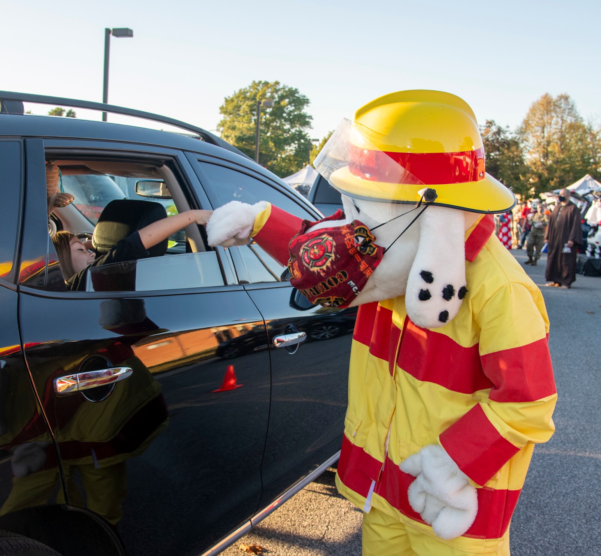 Sparky the Fire Dog greets a child at the deployed families dinner and trunk or treat on Dover Air Force Base, Delaware, Oct. 21, 2021. The quarterly dinners give thanks to families whose loved ones are deployed or on extended assignments. (U.S. Air Force photo by Tech. Sgt. Nicole Leidholm)