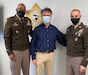 Two U.S. Army Soldiers pose for a photo with a civilian.