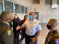 Two U.S. Army Soldiers speak with a sheriff.