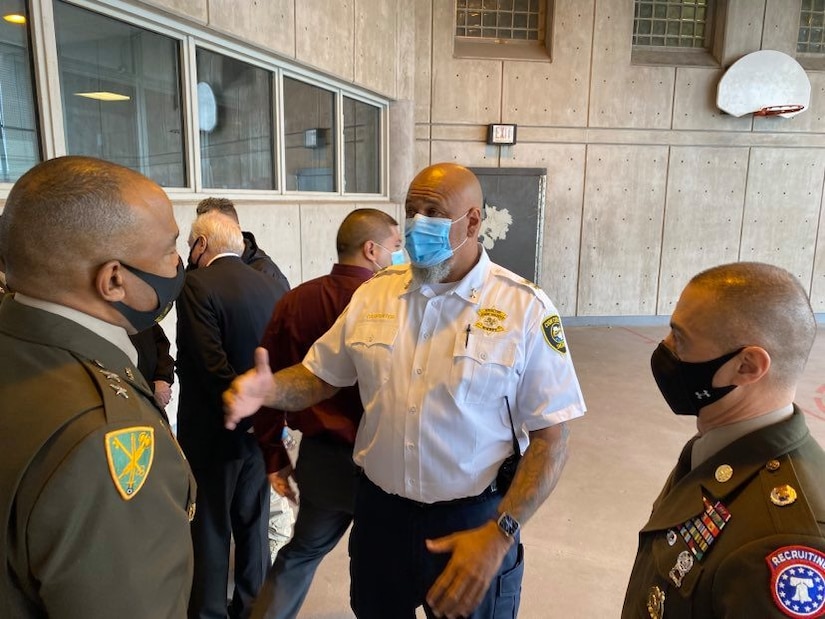 Two U.S. Army Soldiers speak with a sheriff.