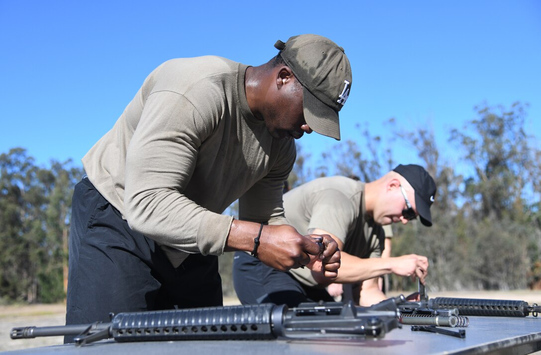 Tech Sgt. Terrance Fortson, 30th Security Forces Squadron launch operations support, and Tech Sgt. Paul Olmos, 30th SFS flight chief, and, compete in the weapons assembly and disassembly event during West Coast Warriors First Responders Appreciation Week  at Vandenberg Space Force Base, Calif., Oct. 15, 2021.. (U.S. Space Force photo by Airman 1st Class Rocio Romo)