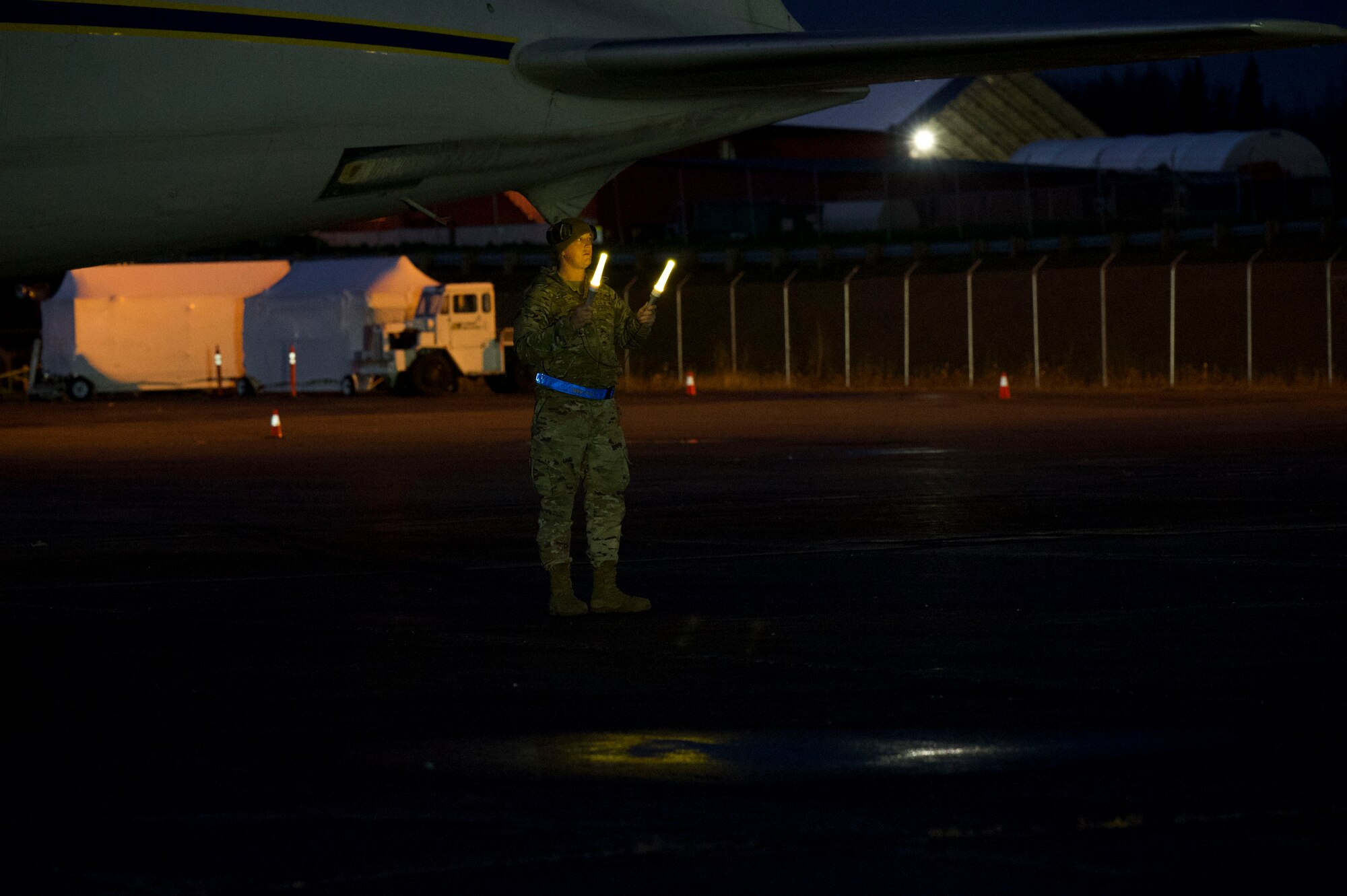 U.S. Air Force Staff Sgt. Timothy Barnwell, 732nd Air Mobility Squadron air freight supervisor, spots a tractor-trailer truck up to a Douglas DC-6 during the Nodal Lightning exercise at Ted Stevens International Airport in Anchorage, Alaska, Oct. 19, 2021. The Nodal Lightning exercise allowed the 732nd AMS personnel to respond efficiently and effectively to contested or degraded contingency environments.