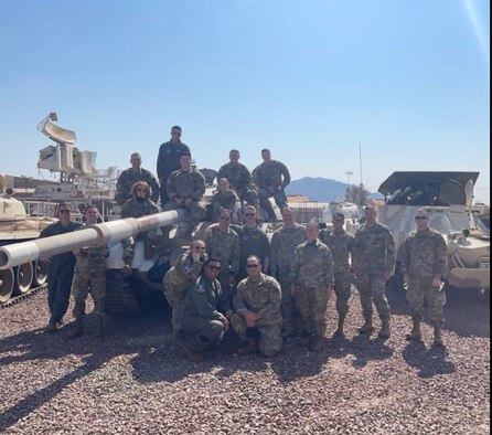 photo of U.S Airmen standing in front of and on a tank