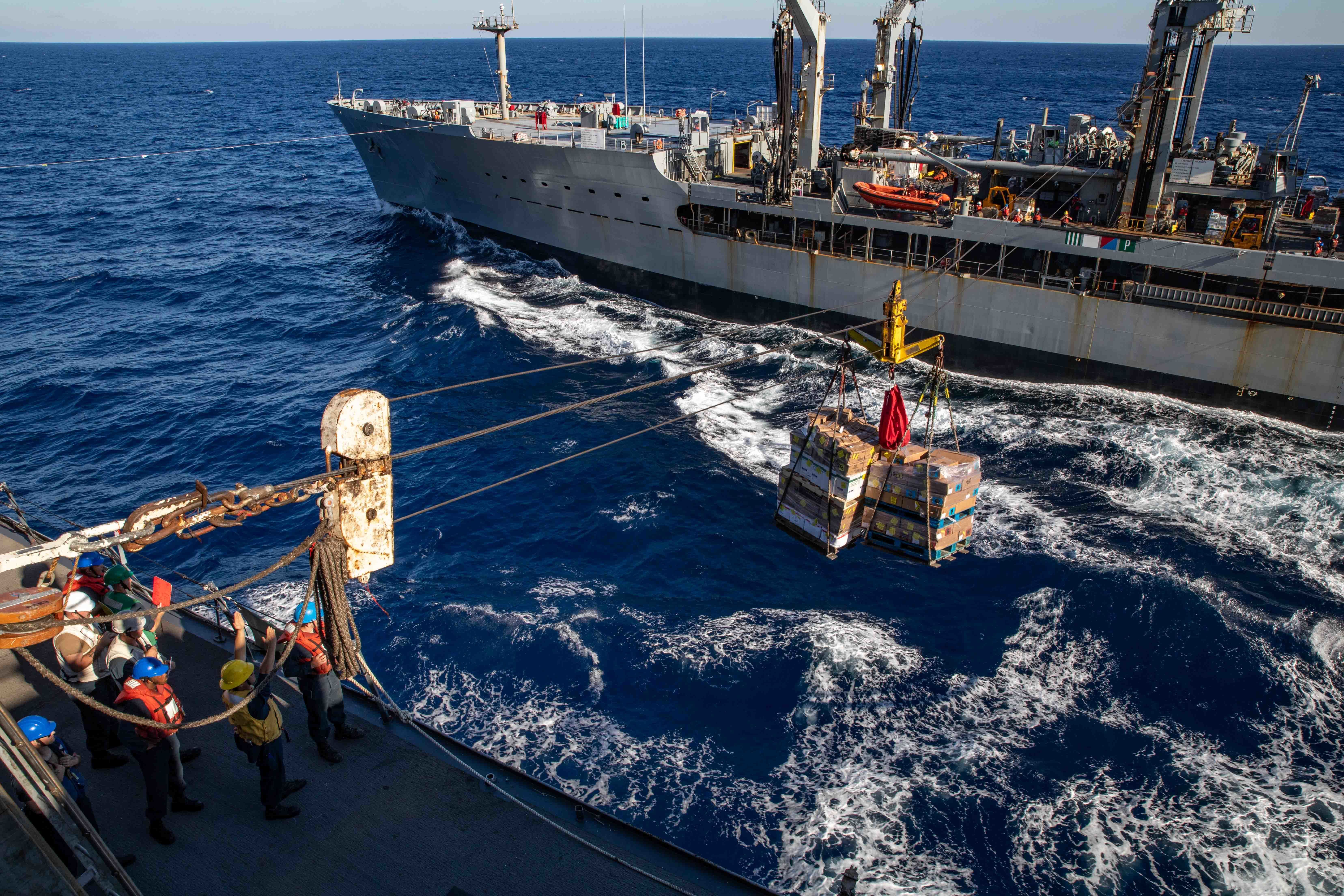 USS Arlington (LPD 24), left, receives supplies from the Henry J. Kaiser-class fleet replenishment oiler USNS Leroy Grumman (T-AO 195) during a replenishment-at-sea, Oct. 23, 2021.