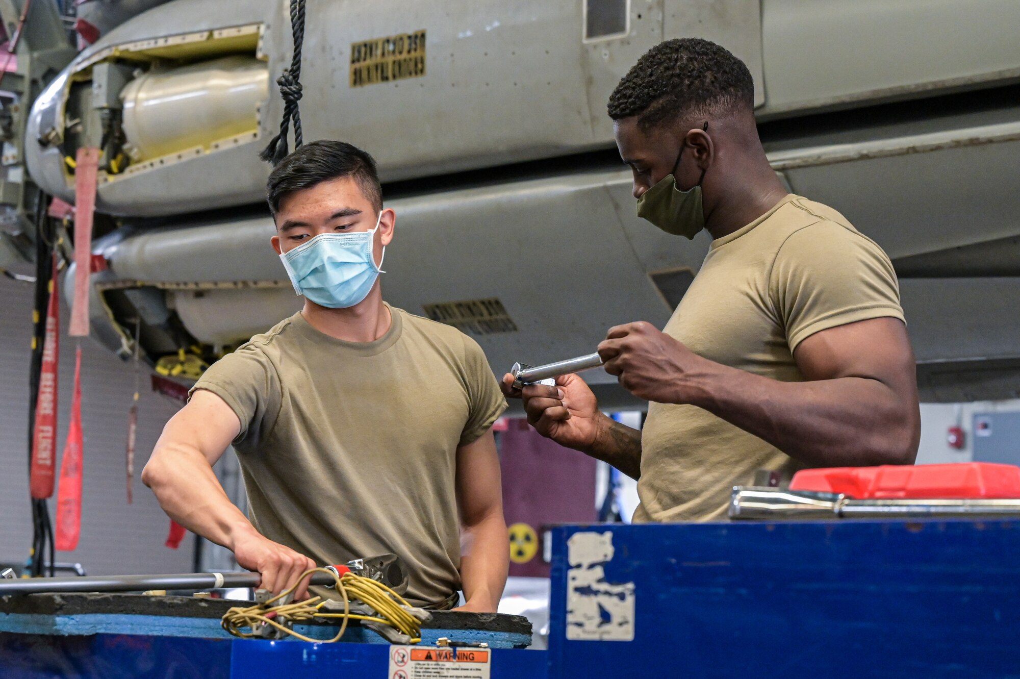 Senior Airman Sterling Brooks, 2nd Munitions Squadron weapons maintenance team member, and Airman 1st Class, Paxton Liu, 2nd MUNS weapons maintenance team member, organize tools used to conduct maintenance on the Air-launched Cruise Missile at Barksdale Air Force Base, Louisiana, Oct. 20, 2021. The exercise was conducted to observe the readiness capabilities of Airmen during a real life scenario. (U.S. Air Force photo by Airman 1st Class Jonathan E. Ramos)