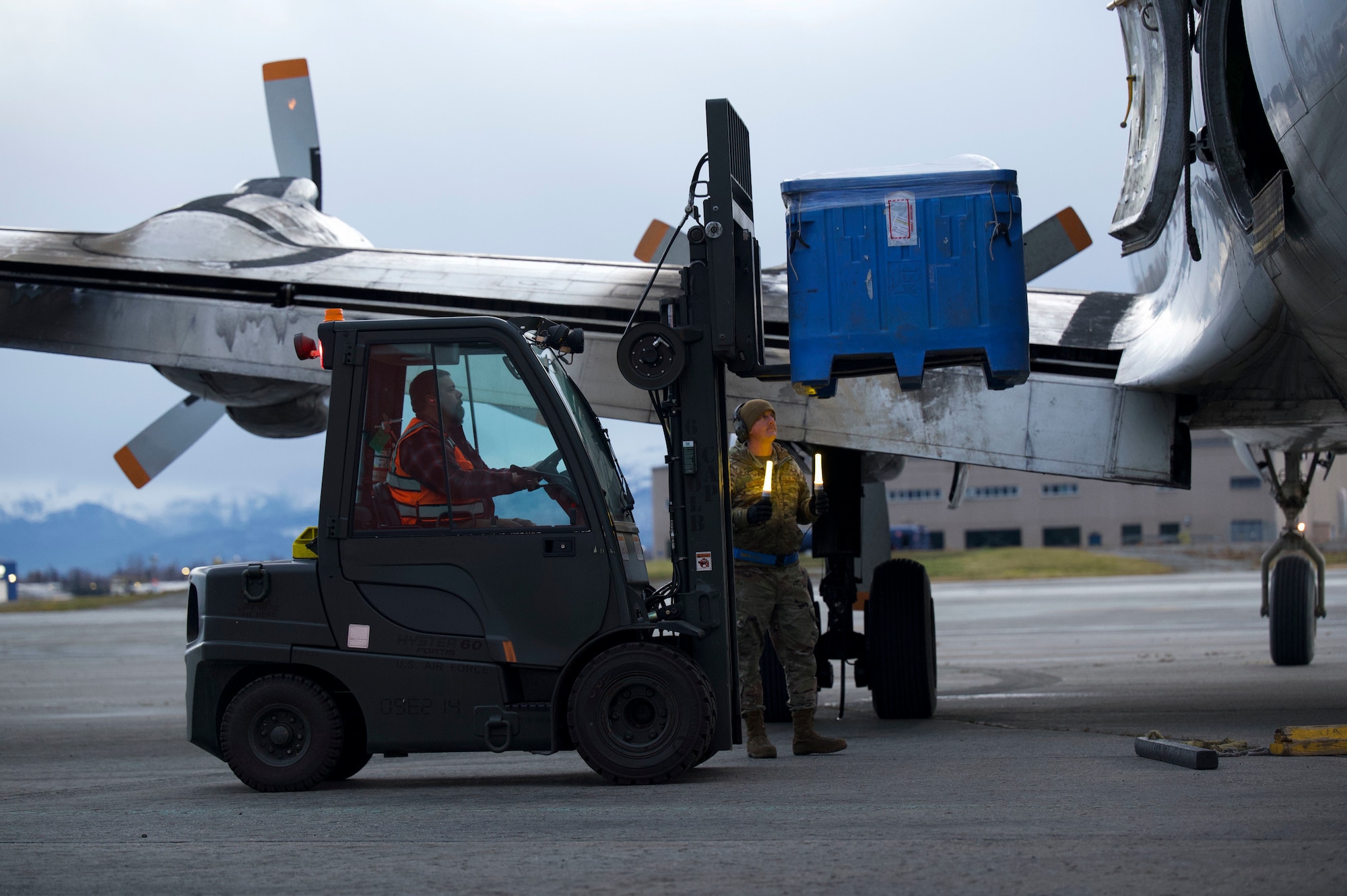 Air Force Staff Sgt. Timothy Barnwell and Timothy Murray load rations onto a Douglas DC-6 to deliver to a Long Range Radar Site during Nodal Lightning exercise at Ted Steven International Airport in Anchorage, Alaska, Oct. 19, 2021. he Nodal Lightning exercise allowed the 732nd AMS personnel to respond efficiently and effectively to contested or degraded contingency environments. Barnwell and Murray are assigned to the 732nd Air Mobility Squadron as freight supervisor and motor vehicle operator, respectively.