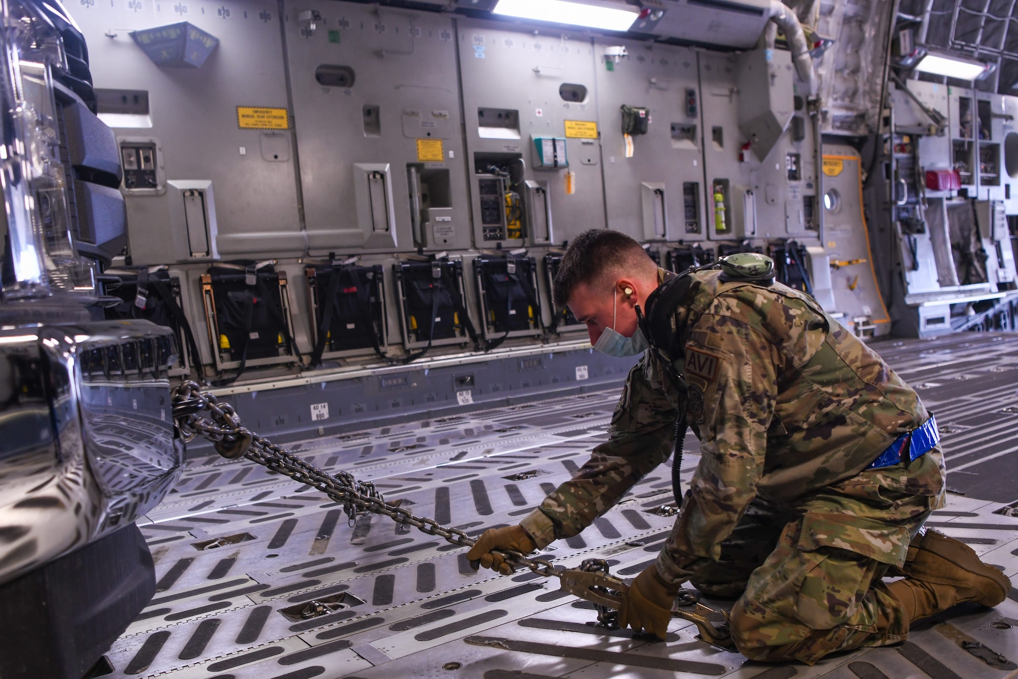 U.S. Air Force Staff Sgt. Joshua Goodhart, a 732nd Air Mobility Squadron avionics technician, fastens a tie-down restraint after loading a truck onto a C-17 Globemaster III during the Nodal Lightning exercise at Ted Stevens International Airport in Anchorage, Alaska, Oct. 19, 2021. The Nodal Lightning exercise allowed 732nd AMS personnel to respond efficiently and effectively to contested or degraded contingency environments.