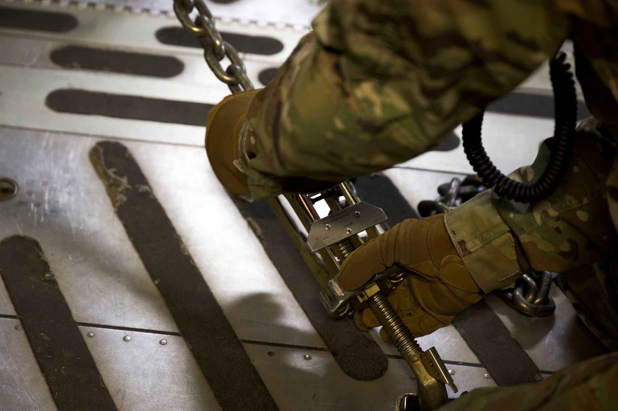 Air Force Staff Sgt. Josh Goodhart, 732nd Air Mobility Squadron aircraft maintainer, applies a tie-down restraint after loading a truck onto a C-17 Globemaster III during the Nodal Lightning exercise at Ted Steven International Airport in Anchorage, Alaska, Oct. 19, 2021. The Nodal Lightning exercise allowed the 732nd AMS personnel to respond efficiently and effectively to contested or degraded contingency environments.