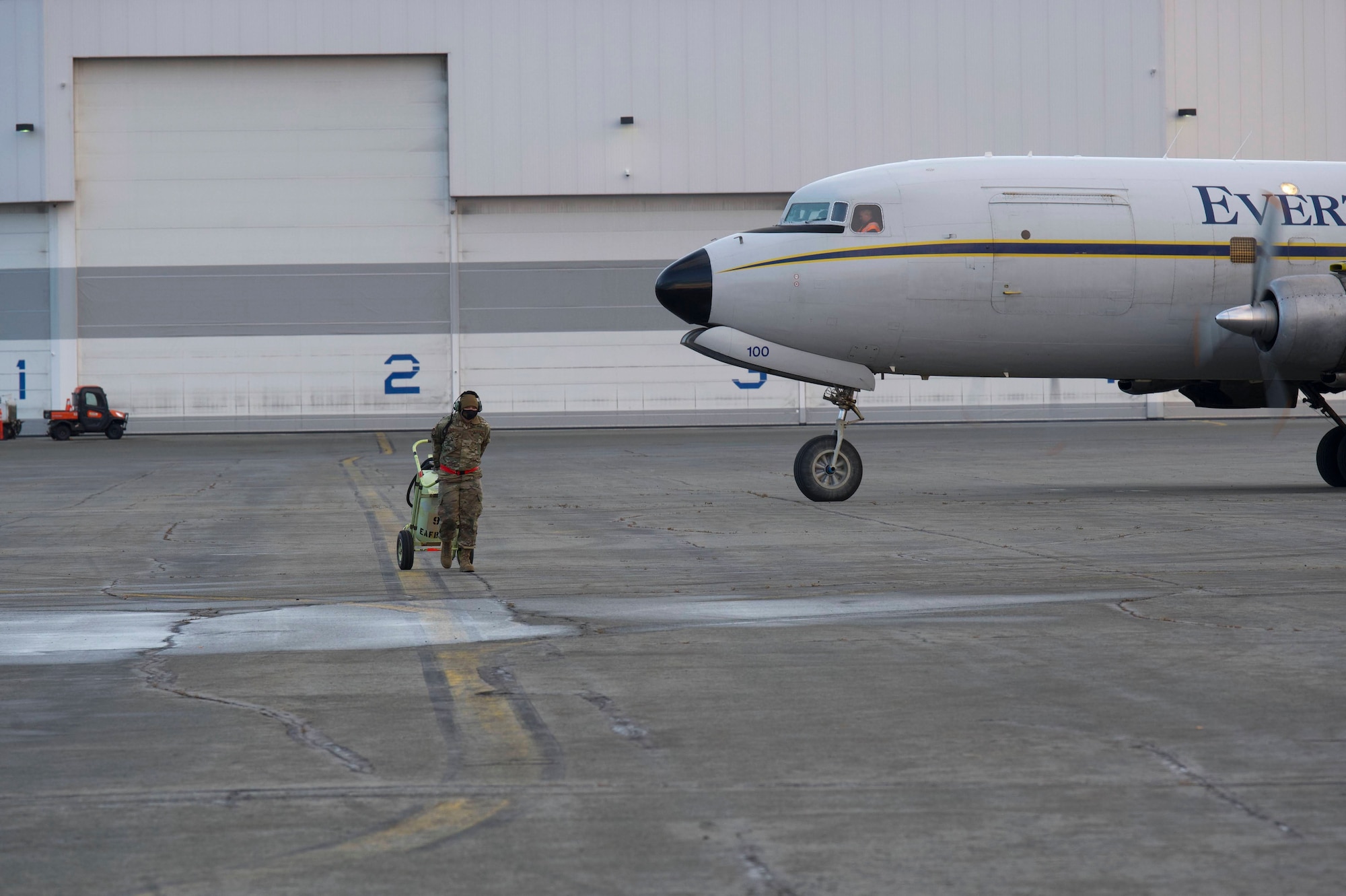 Air Force Staff Sgt. Anthony Mahon, 732nd Air Mobility Squadron aircraft maintenance craftsman, removes a fire bottle in front of a Douglas DC-6 before it departs during the Nodal Lightning exercise at Ted Steven International Airport in Anchorage, Alaska, Oct. 19, 2021. The Nodal Lightning exercise allowed the 732nd AMS personnel to respond efficiently and effectively to contested or degraded contingency environments.