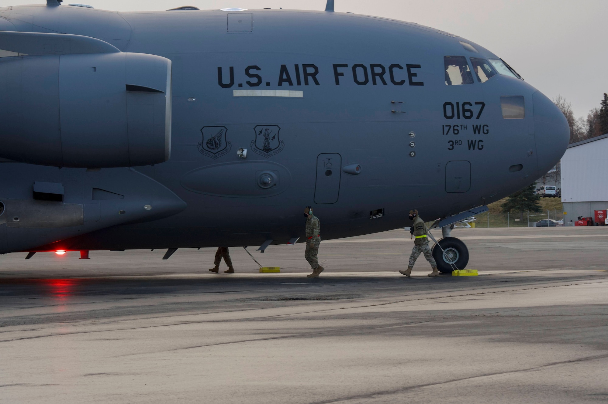 732nd Air Mobility Squadron multi-capable Airmen prepares to chock a C-17 Globemaster III during the Nodal Lightning at Ted Steven International Airport in Anchorage, Alaska, Oct. 19, 2021. The Nodal Lightning exercise allowed the 732nd AMS personnel to respond efficiently and effectively to contested or degraded contingency environments.