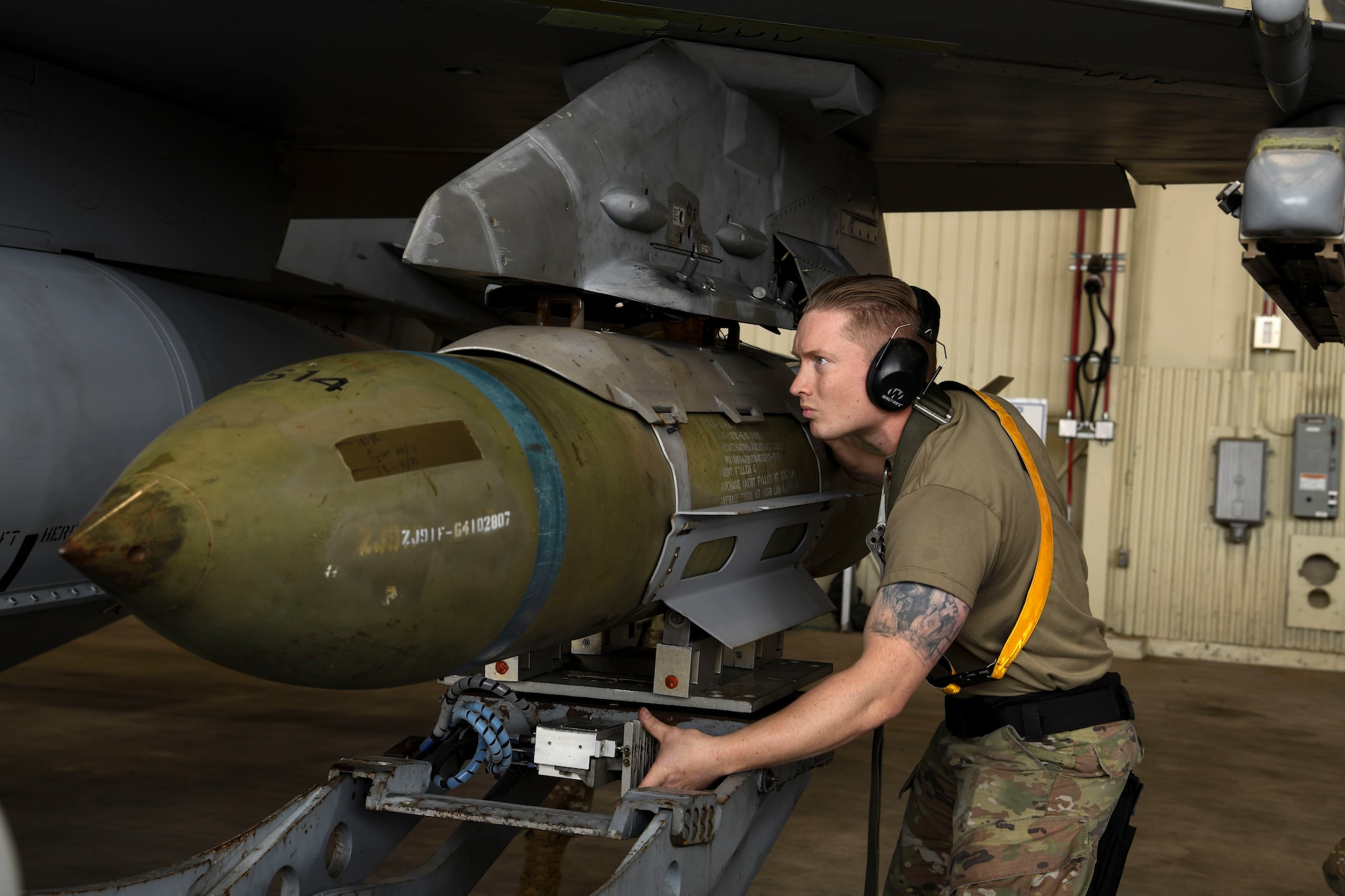 Staff Sgt. Alexander Beedy, 80th Aircraft Maintenance Unit weapons load crew member, loads GBU-31 version three onto an F-16 Fighting Falcon during the Third Quarter Load Crew Competition at Kunsan Air Base, Republic of Korea, Oct. 16, 2021. Three teams competed in four categories to include dress and appearance, a weapons knowledge test, a toolbox inspection and a weapons load. (U.S. Air Force photo by Staff Sgt. Jesenia Landaverde)