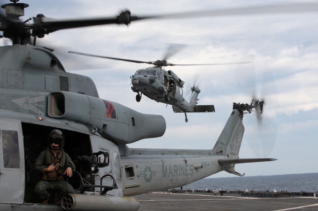 A U.S. Marine UH-1Y Venom and Navy MH-60S Seahawk land aboard the amphibious dock landing ship USS Gunston Hall (LSD 44), Oct. 21, 2021. LSD 44, a support vessel for the 22nd MEU and Amphibious Squadron (PHIBRON) 6, is underway for PHIBRON-MEU Integrated Training (PMINT) in preparation for future deployment. PMINT is the first at-sea period in the MEU’s Redeployment Training Program; it aims to increase interoperability and build relationships between Marines and Sailors. (U.S. Marine Corps photo by Sgt. Mason Roy)