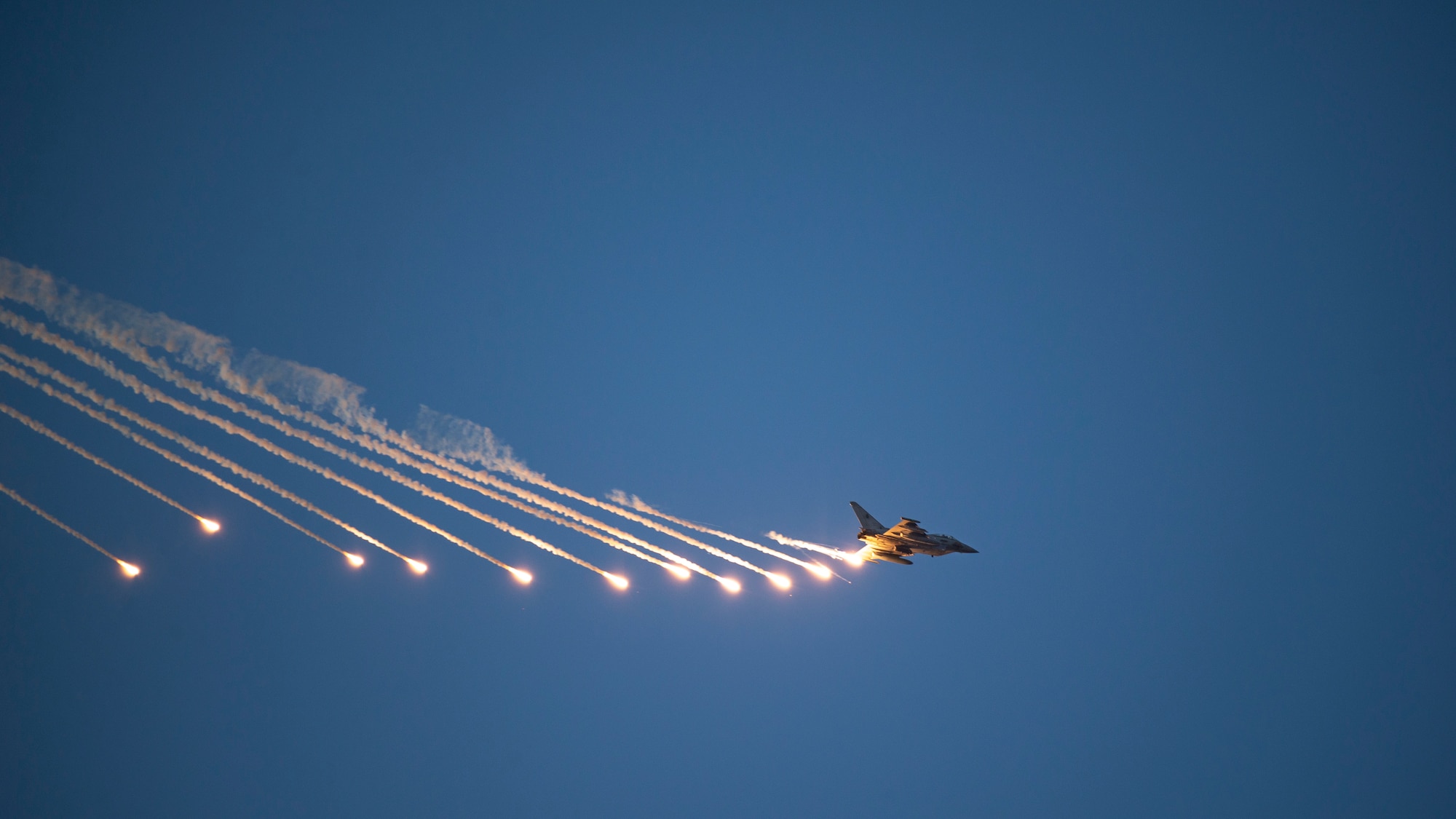 Italian Air Force (Aeronautica Militare) Eurofighter Typhoon deploys chaff and flares countermeasures above Udairi Range, Kuwait, Oct. 21, 2021. USAF JTACs deployed to the 82nd EASOS, along with the U.S. Army 1st Battalion 194th Armor Regiment joint fires observers in-training, and the ITAF Task Group Typhoon practiced close air support, fostered enduring partnerships and advanced its decisive combat dominance during a live-fire training exercise. (U.S. Air Force photo by Staff Sgt. Ryan Brooks)