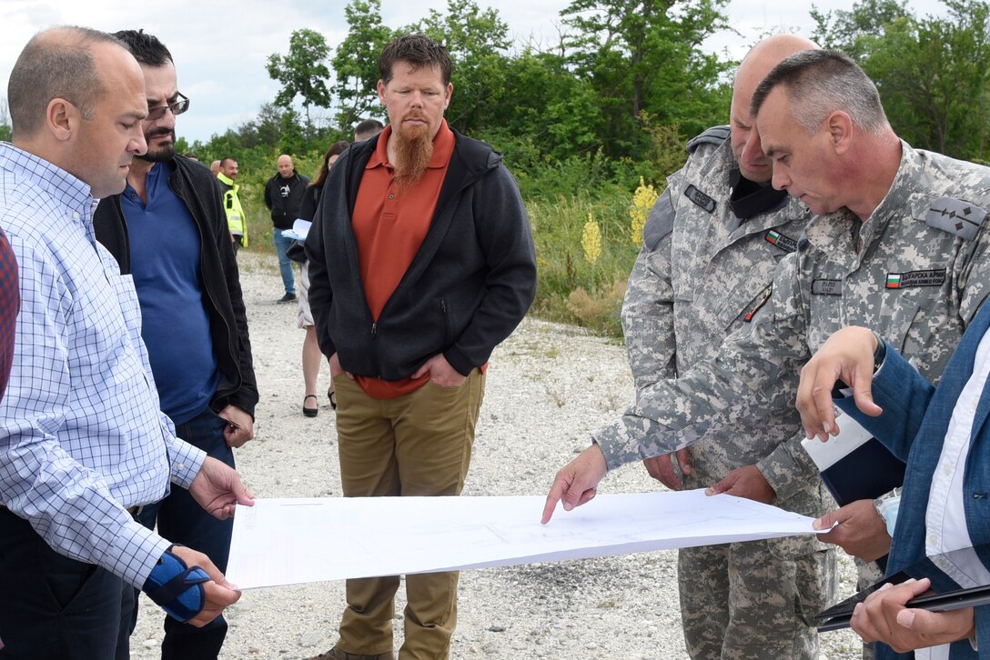 U.S. Army Corps of Engineers, Europe District Southern Europe Area Engineer Bryce Jones, left, provides an overview of ongoing and upcoming construction projects to members of the Bulgarian Air Force at Graf Ignatievo Air Base in Bulgaria June 16, 2021. Jones was recognized as the U.S. Army Corps of Engineers Administrative Contracting Officer of the Year during a virtual ceremony October 25, 2021 for his work in support of the U.S. Army Corps of Engineers missions in Bulgaria as well as several other Southern European countries. (U.S. Army photo by Alfredo Barraza)