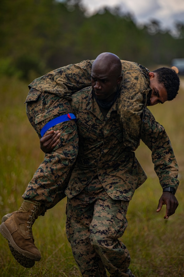 MSgt. Jeremy Singleton, The G-1 Manpower Chief of Marine Forces Reserve, fireman carries a Marine to safety as part of a simulated event during a field exercise at Camp Villere, Slidell, Louisiana, October 21, 2021. The field exercise incorporated activities that provided guidance for a Basic Skills Test to ensure all Marines sustain basic combat skills and knowledge to be successful on the battlefield. (Marine Corps photo by Lance Cpl. Samwel Tabancay)