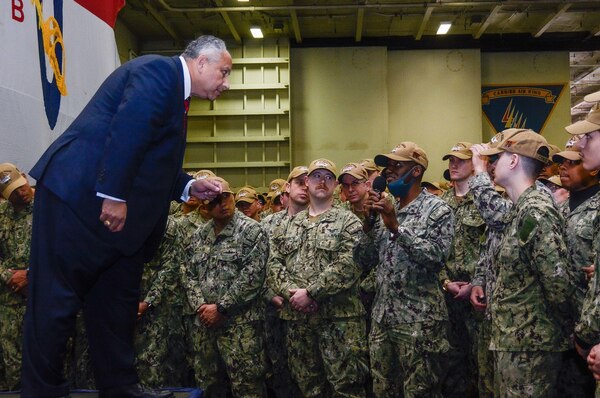 Secretary of the Navy Carlos Del Toro answers questions from the crew during an all hands call in the hangar bay of the U.S. Navy's only forward-deployed aircraft carrier USS Ronald Reagan (CVN 76)