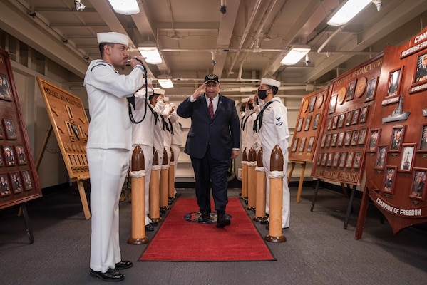 Secretary of the Navy Carlos Del Toro salutes sideboys on the ceremonial quarterdeck of the U.S. Navy's only forward-deployed aircraft carrier USS Ronald Reagan (CVN 76).