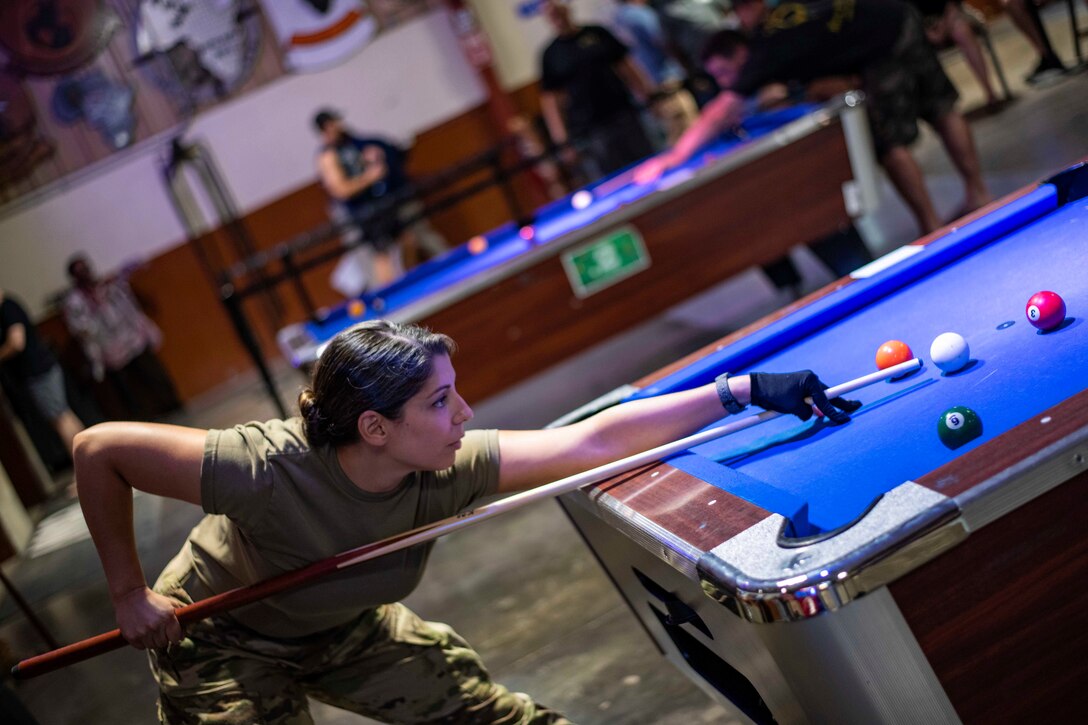 A soldier plays pool.