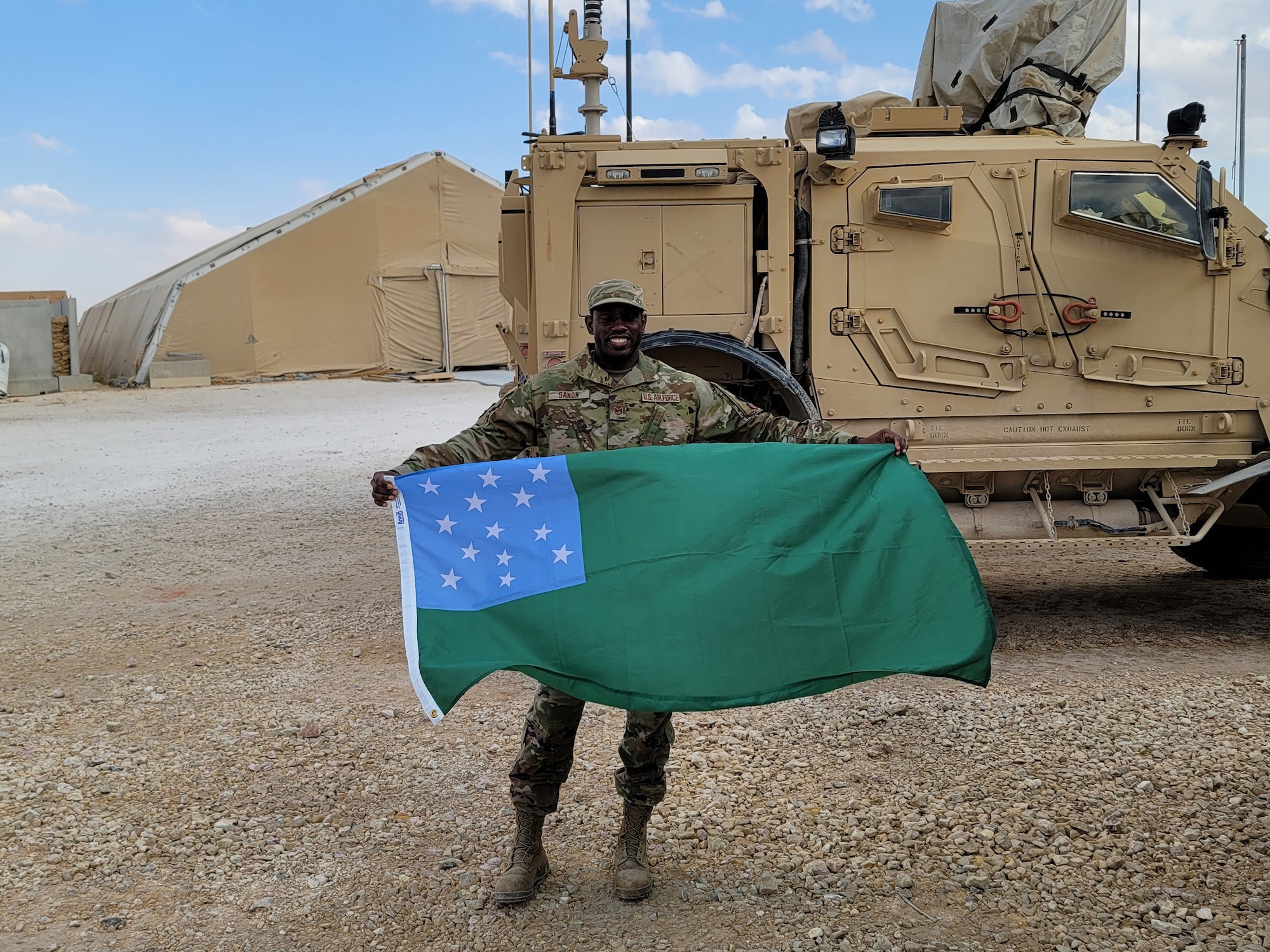 U.S. Air Force Tech. Sgt. Gladimir Sanon, 158th Civil Engineer Squadron readiness NCOIC, Vermont Air National Guard, holds the Green Mountain Boy battle flag at an air base in Southwest Asia, April 2, 2021