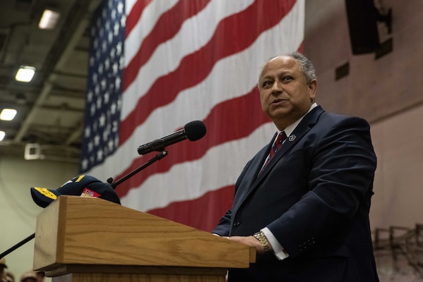 Secretary of the Navy Carlos Del Toro speaks to the crew during an all hands call in the hangar bay of the U.S. Navy's only forward-deployed aircraft carrier USS Ronald Reagan (CVN 76).