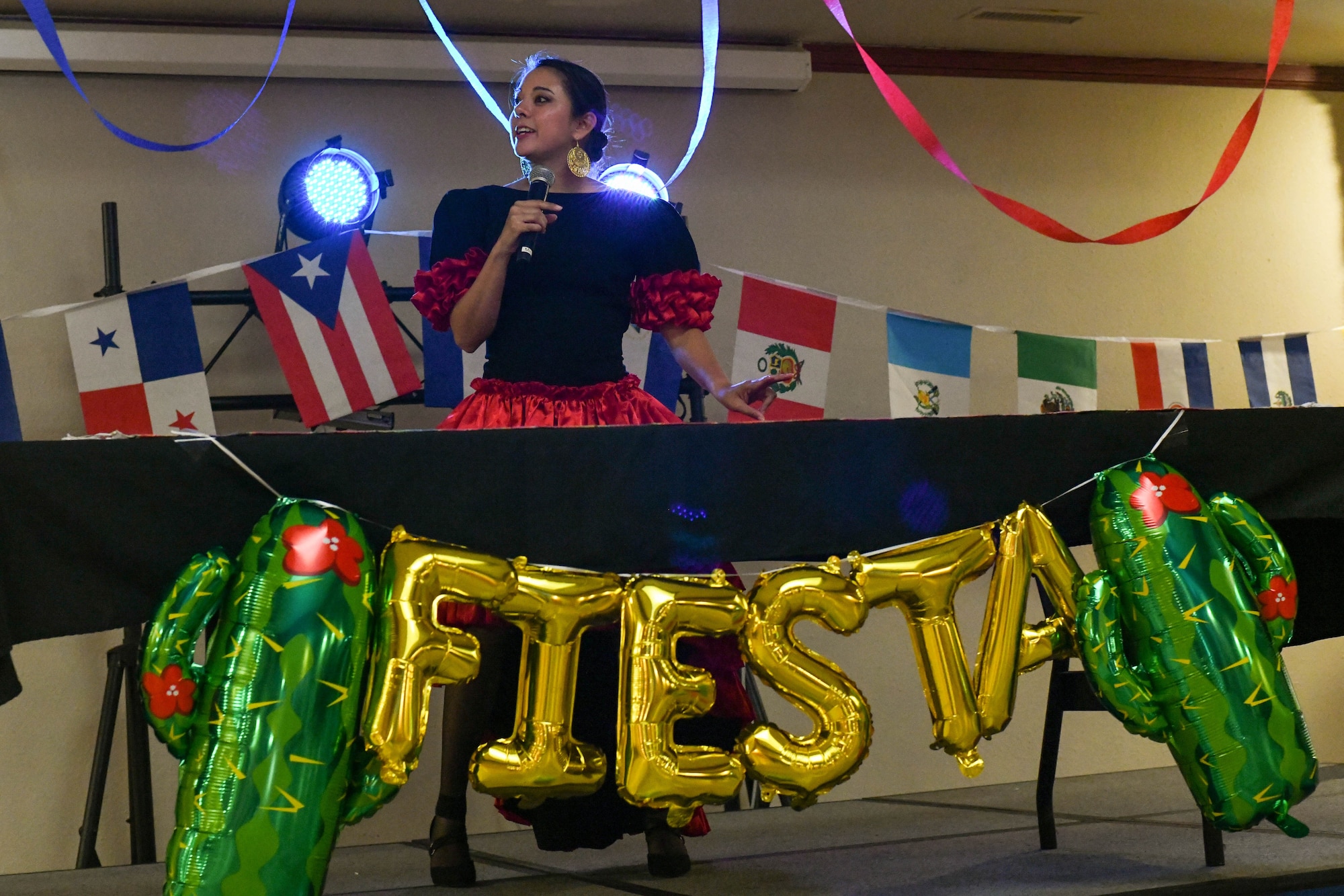 U.S. Air Force Capt. Isabella Zamarron, 97th Logistics Readiness Squadron fuels management flight commander, speaks at a fiesta on Altus Air Force Base, Oklahoma, October 15, 2021. Before introducing the dance group, Zamarron spoke about the significance of celebrating Hispanic Heritage Month. (U.S. Air Force photo by Airman 1st Class Trenton Jancze)