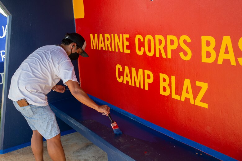 Uriah Perez, the Marine Corps Base (MCB) Camp Blaz community liaison specialist, paints a bus stop located across from Naval Computer and Telecommunications Station (NCTS) Guam, Oct. 20, 2021.