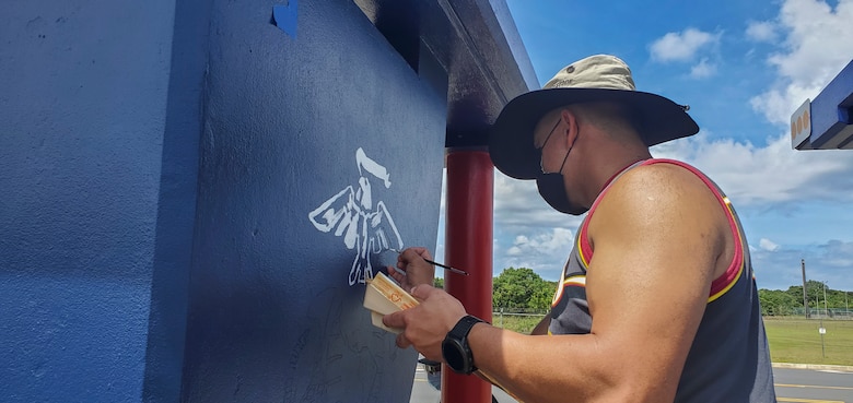 Bruce Meno, the Marine Corps Base (MCB) Camp Blaz emergency manager, paints a bus stop located across from Naval Computer and Telecommunications Station (NCTS) Guam, Sept. 28, 2021.