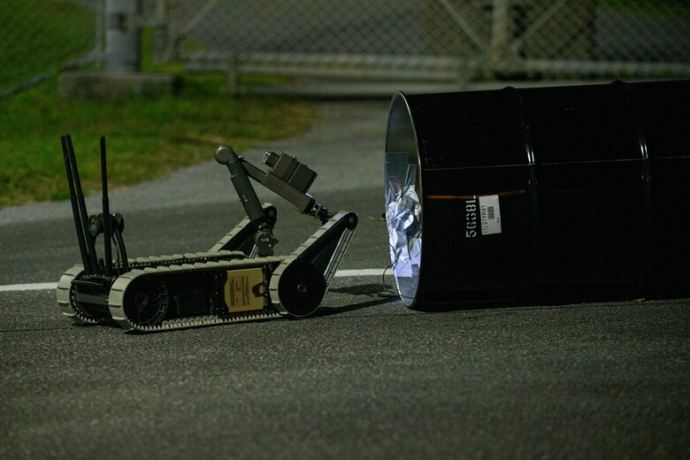 A Small Unmanned Ground Vehicle, controlled by a tablet-based interface, visually inspects a vehicle-borne improvised explosive device during Operation Constant Vigilance on Camp Courtney, Okinawa, Japan, Oct. 19, 2021. After a visual confirmation of a simulated vehicle-borne improvised explosive device, Security Guard Force, Camp Courtney, and Explosive Ordnance Disposal, Marine Corps Base Camp Butler, conducted response measures to include detainee handling, EOD robotics techniques, and vehicle inspection procedures. Constant Vigilance is an island-wide force protection condition evaluation and crisis response to validate regional, installation, camp, and tenant antiterrorism and mission assurance plans and policies. (U.S. Marine Corps photo by Lance Cpl. Alex Fairchild)