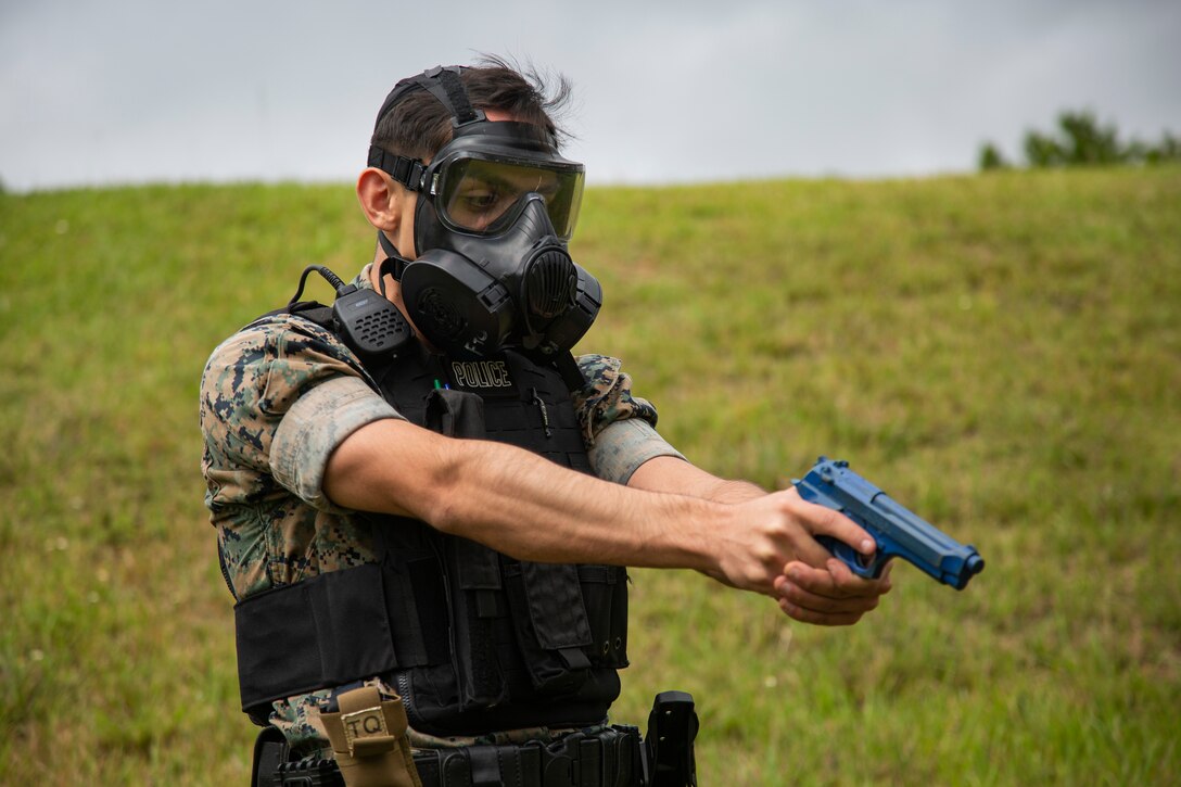 U.S. Marine Corps Lance Cpl. Adam Montez, a desk sergeant with Provost Marshal’s Office, Camp Schwab, Marine Corps Installations Pacific, aims his notional weapon during a simulated missile strike for Exercise Constant Vigilance on Camp Schwab, Okinawa, Japan, Oct. 21, 2021. Following a simulated missile strike, Marines with MCIPAC and local emergency services conducted tactical casualty care and medical evacuation procedures, chemical radiological and nuclear containment efforts, and air transportation to simulate an emergency environment and practice response measures. Constant Vigilance is an island-wide force protection condition evaluation and crisis response to validate regional, installation, camp, and tenant anti-terrorism and mission assurance plans and policies. (U.S. Marine Corps photo by Lance Cpl. Zachary Larsen)