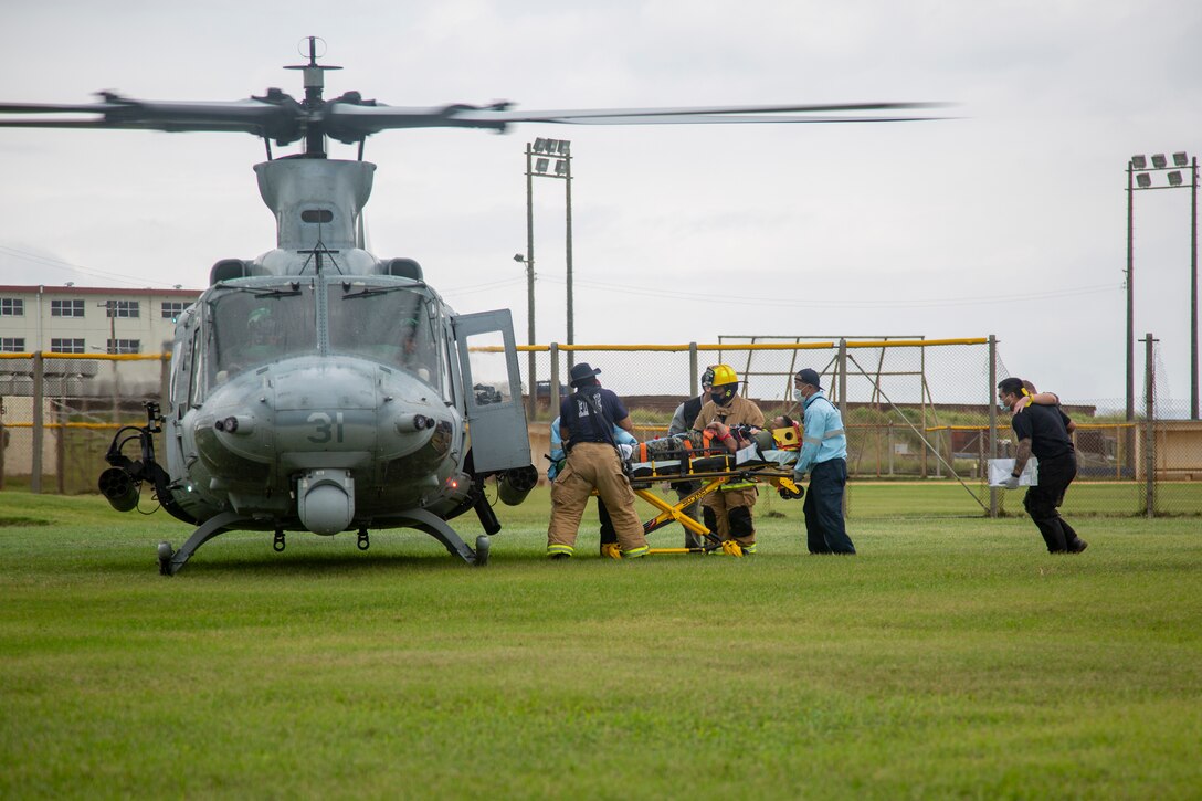 U.S. Marines and locals with Marine Corps Installations Pacific load victims into a Marine Corps UH-1Y Huey with Marine Light Attack Helicopter Squadron 169 for a medical evacuation following a simulated missile strike for Exercise Constant Vigilance on Camp Schwab, Okinawa, Japan, Oct. 21, 2021. Following a simulated missile strike, Marines with MCIPAC and local emergency services conducted tactical casualty care and medical evacuation procedures, chemical radiological and nuclear containment efforts, and air transportation to simulate an emergency environment and practice response measures. Constant Vigilance is an island-wide force protection condition evaluation and crisis response to validate regional, installation, camp, and tenant anti-terrorism and mission assurance plans and policies. (U.S. Marine Corps photo by Lance Cpl. Zachary Larsen)